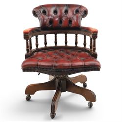 Captains swivel desk chair upholstered in oxblood leather, buttoned back and seat, shaped arm bow raised on turned spindles, five spoke base raised on castors