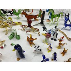 Quantity of hand blown glass figures of animals, to include example modelled as an elephant beneath trees bearing fruit, stylised cockatoo perched upon spiralled branch, giraffe, dogs with their leg cocked beneath streetlight, fox with catch in its mouth, octopus, various birds and dogs, penguins, fish, deer etc, tallest H27cm