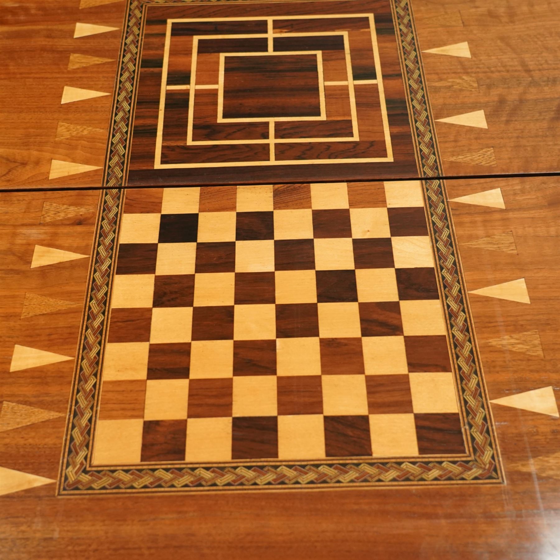 19th century mahogany fold-over card table, the crossbanded rectangular top opening to reveal an inlaid games centre with chessboard and backgammon designs, raised on turned and reeded legs with extending rear supports