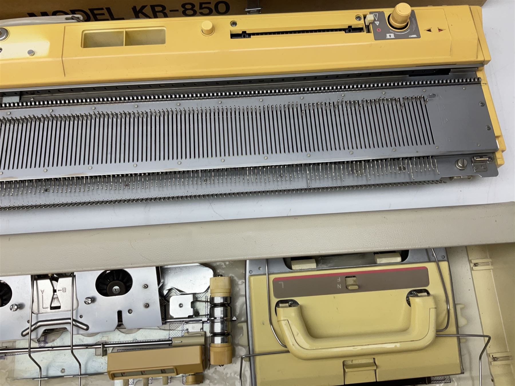  Brother cased knitting machine model KH-890 together with Brother Ribbing attachment model KH-850, knitting machine yarn cones in assorted colours, selection of knitting patterns etc