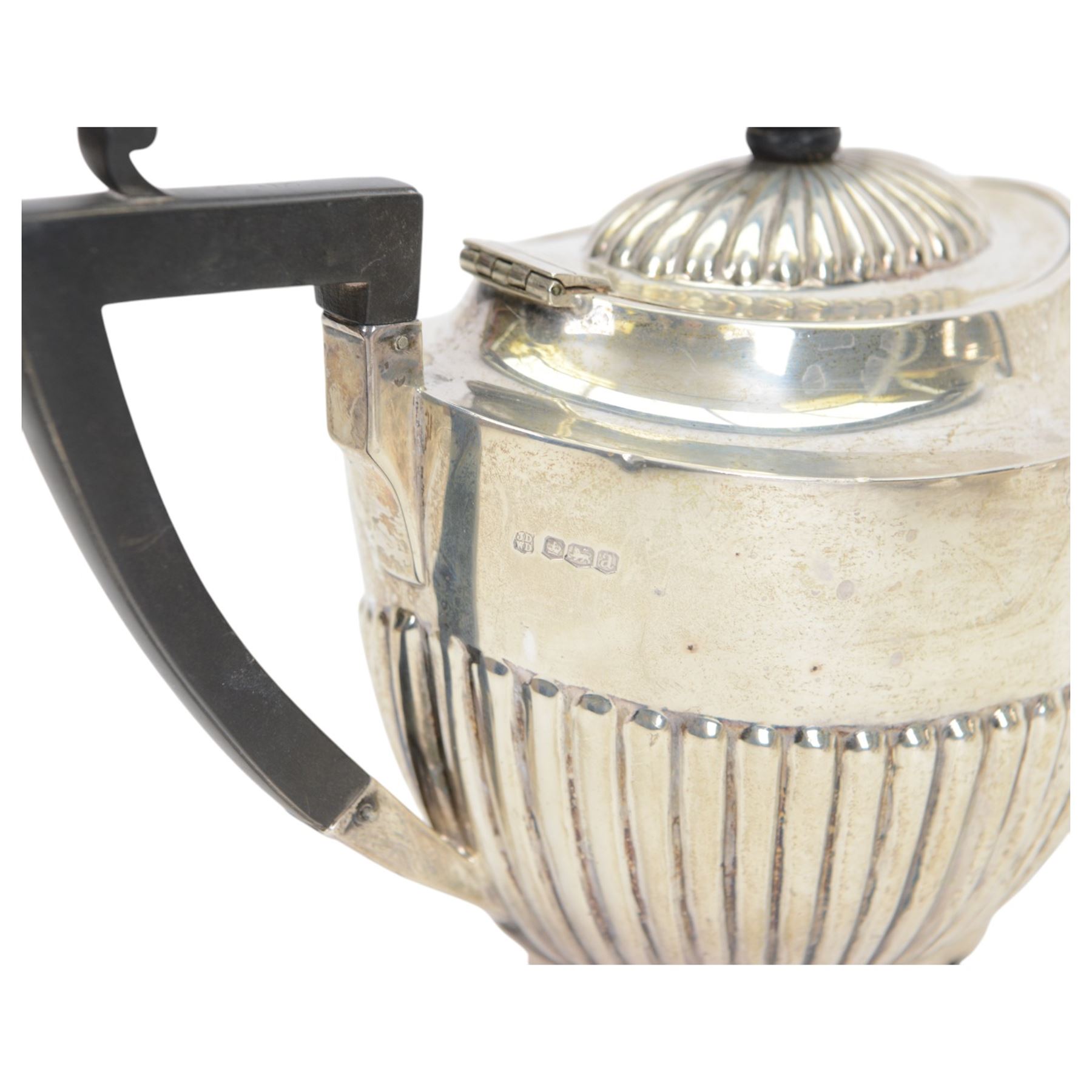 Early 20th century four piece silver tea service, comprising teapot, hot water pot, open sucrier and milk jug, all of oval part fluted form, the teapot and hot water pot with Bakelite type handles and finials, hallmarked James Deakin & Sons (John & William F Deakin), Sheffield 1918