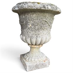 Set of four weathered composite stone urns of campana form, the everted leaf-moulded rolled rim over a body decorated with scrolling fruiting grapevines in relief, over a gadrooned underbelly and waisted socle, lobed collar on square base