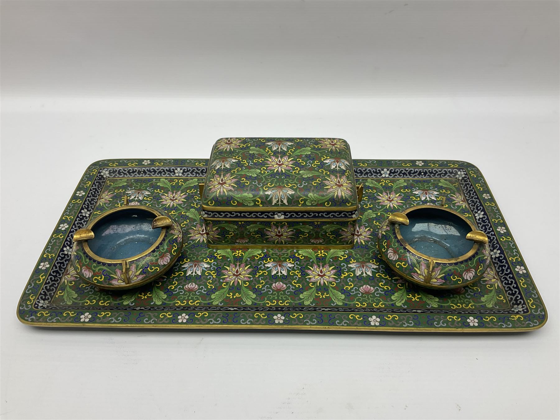 20th century Chinese cloisonne enamel smoking set, comprising two ashtrays, box and tray, with floral and foliate scrolling on green ground