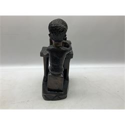 African hardwood figure carved from the solid as a man seated at a treadle sewing machine H33cm