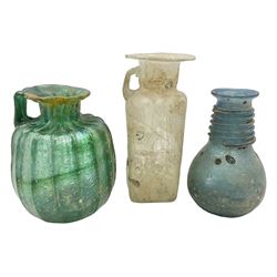 Three pieces of Pompeiian glass, comprising fluted green glass bottle with handle, blue glass ring necked vase and a clear glass bottle with fluted rim, tallest H16cm