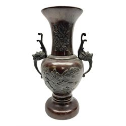 Oriental brass twin-handled vase, of baluster form with fluted rim, decorated in relief with birds amongst peonies, H24cm