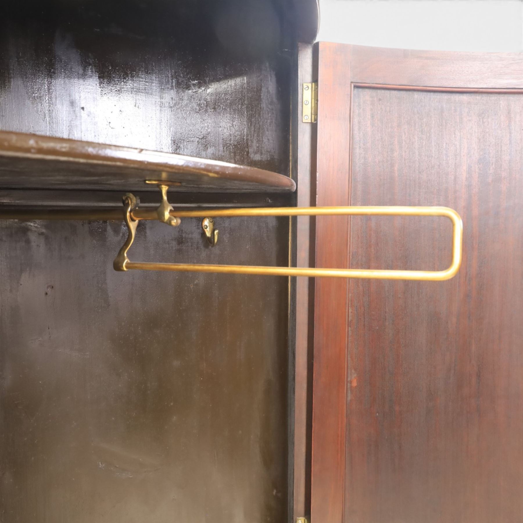 Edwardian inlaid mahogany cylindrical corner hall-robe, projecting cornice, figured veneer and crossbanded door, enclosing hanging hooks and shelf, raised on a plinth base with bracket feet