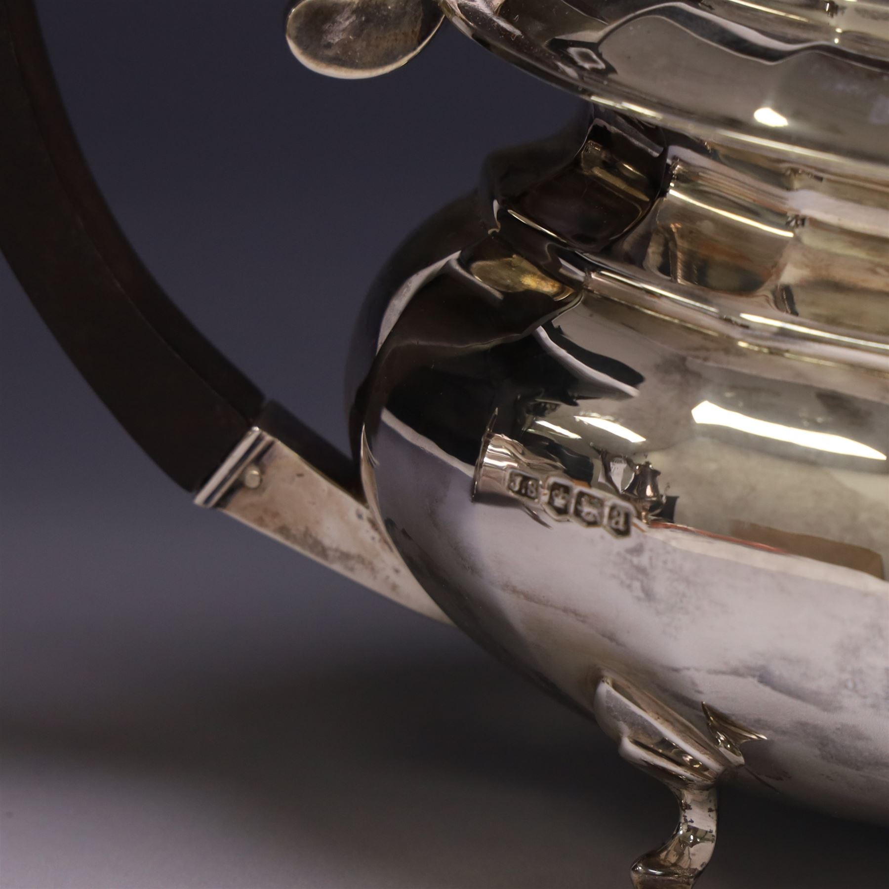 Early 20th century silver four piece tea service, comprising hot water pot, teapot, open sucrier and milk jug, each of part fluted oval form upon four stepped feet, the teapot and hot water pot with ebonised handle and finial, hallmarked Stephenson & Law, Sheffield 1918
