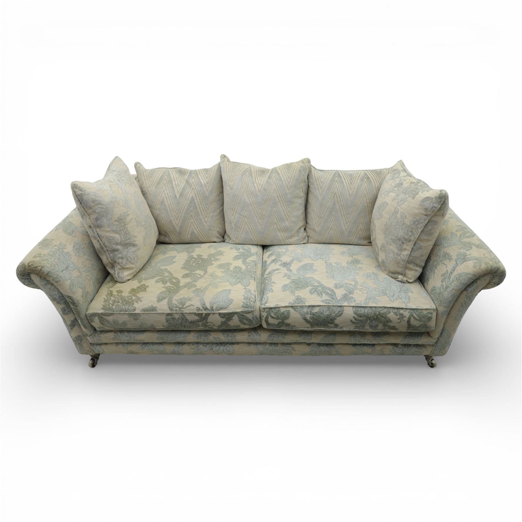 Alstons - 'Lowry' three seater settee, loose cushioned back and seat with additional cushions upholstered in silver and blue floral fabric, supported on square feet with chrome castors to the front