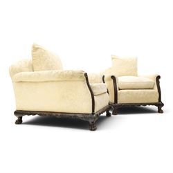 Quality Edwardian carved mahogany lounge suite comprising three-seater settee and pair of armchairs, the sofa with arched back over rolled arms and deep sprung seat, the arm terminals carved with acanthus rosette over gadroon and rope-twist moulding, the shaped apron carved and moulded with scrolling foliate acanthus motifs, terminating to four large front hairy paw and ball feet, upholstered in pale yellow foliate fabric with matching seat and scatter cushions (W200cm D105cm H73cm); the matching deep armchairs (W78cm D95cm H75cm)