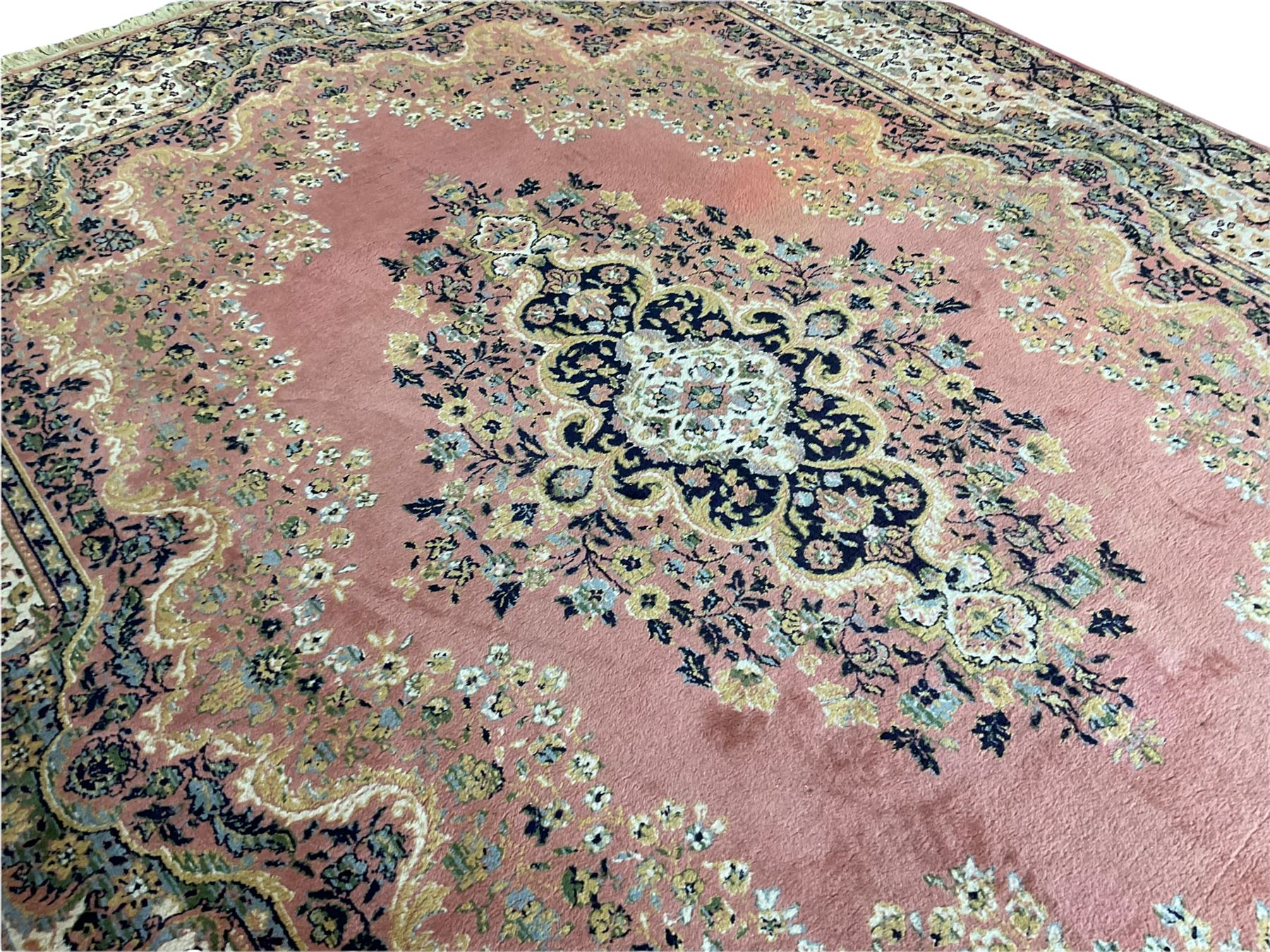 Large Persian design peach ground carpet, the field decorated with floral medallion, multi-band border decorated with repeating flower head pattern