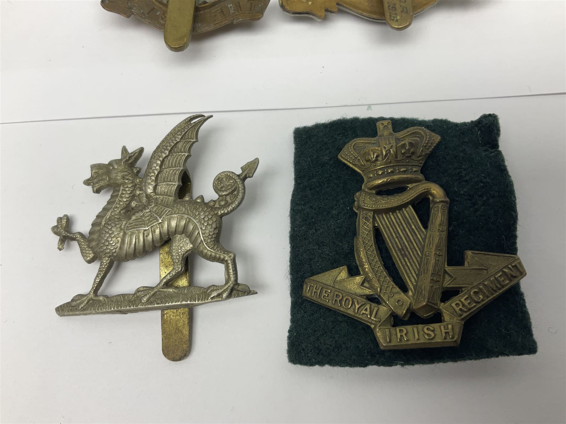 Fourteen cap badges of Irish interest including Royal Dublin Fusiliers inscribed to the slider 'From A. O'Connor 2nd Batt. Dec.2nd 1915', Connaught Rangers, South irish Horse Yeomanry, Inniskilling Fusiliers, Royal Irish Regiment etc; and seven Welsh badges including South Wales Borderers, Welsh Guards, 3rd Bn. Monmouthshire Regt. etc (21)