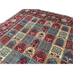Persian Bakhtiari crimson ground carpet, the field divided into seventy panels decorated tree of life motifs, mihrabs and stylised plants, the border decorated with repeating circular medallions formed of Hac motifs, floral pattern guard stripes 