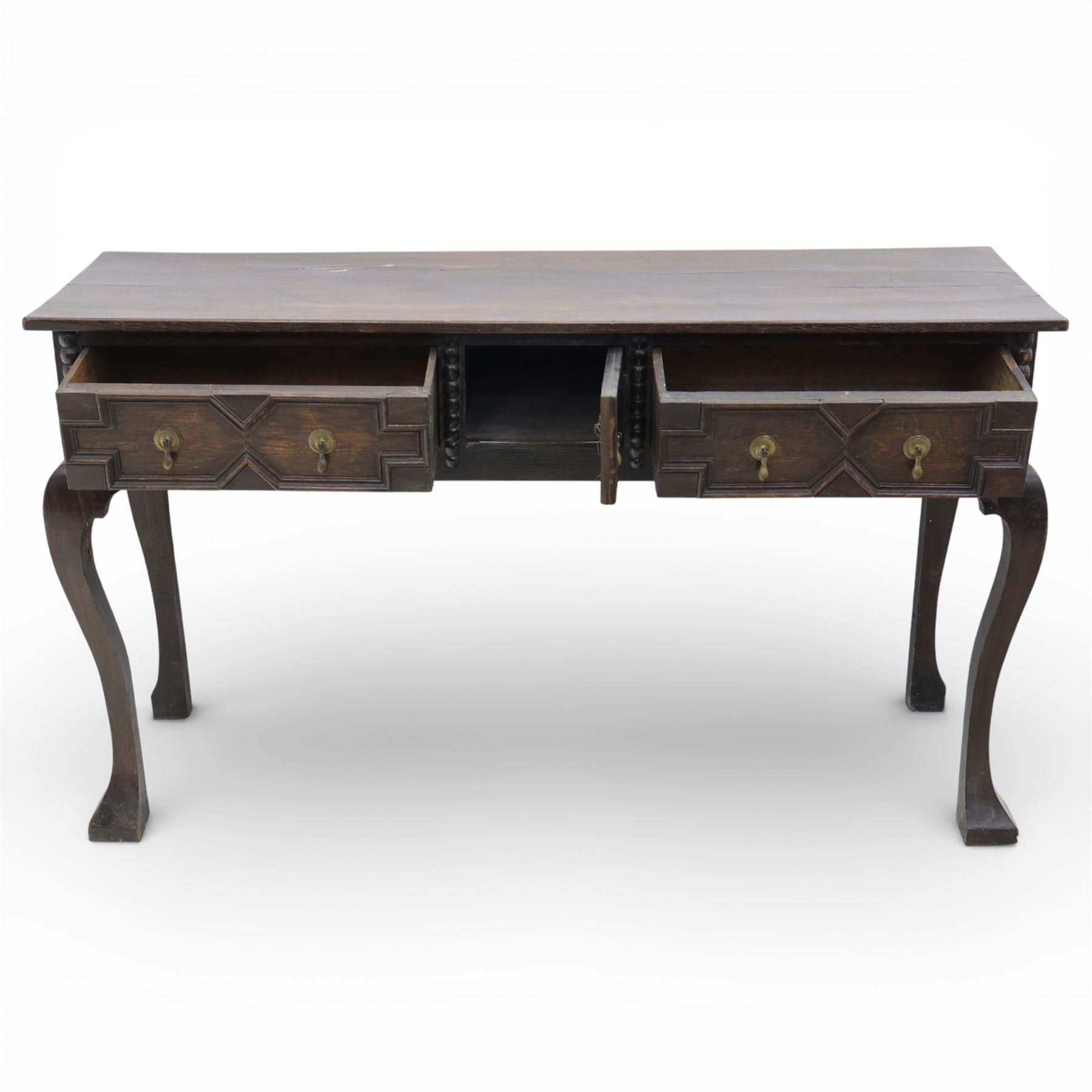 Late 19th century Jacobean revival oak side table, plank top with moulded edge over a central cupboard door and two frieze drawers carved with geometric lozenge motifs and framed by bobbin turned uprights, fitted with brass drop handles, raised on shaped cabriole supports with block feet