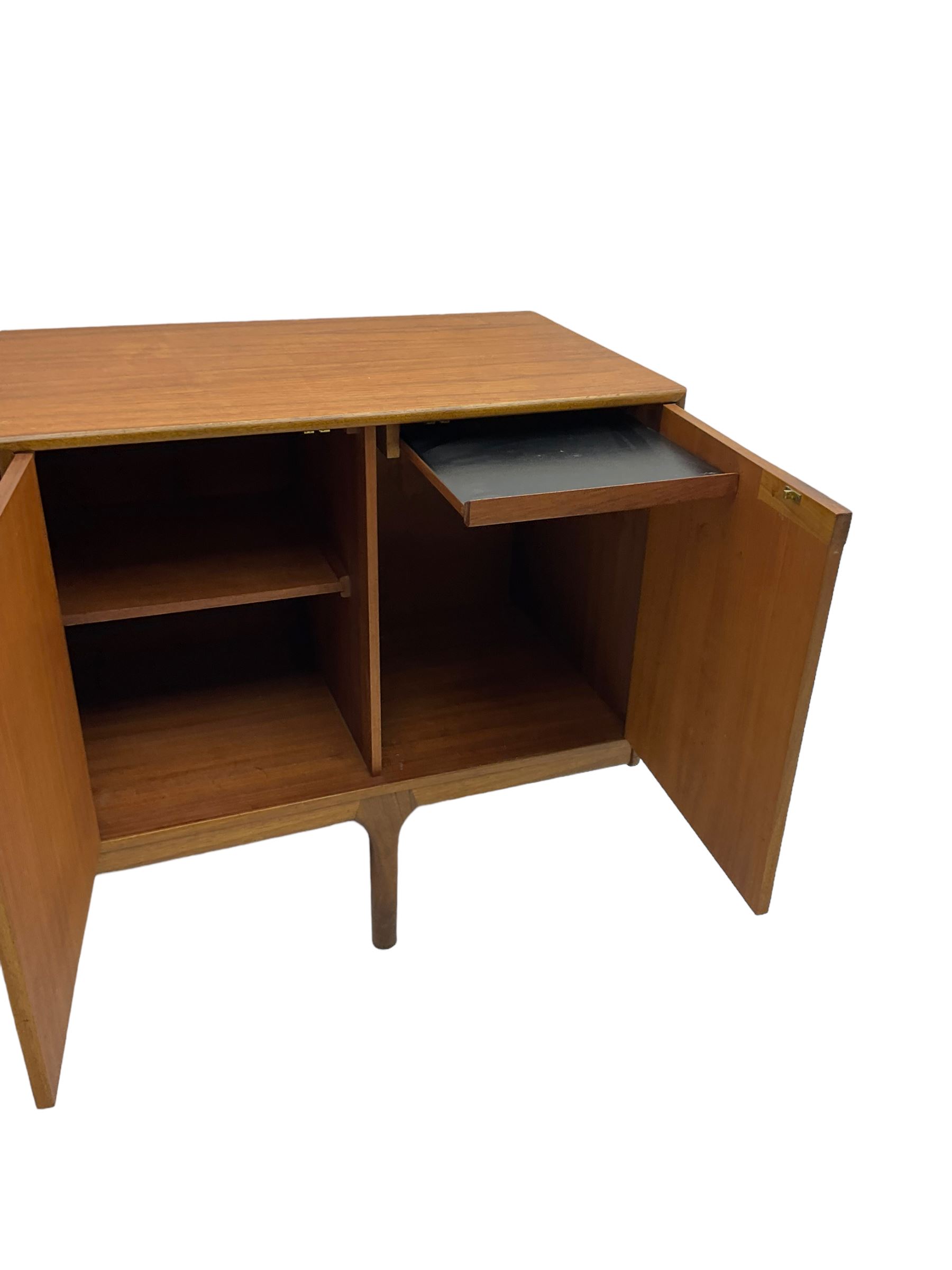 Tom Robertson for AH McIntosh & Co of Kirkaldy - mid-20th century teak sideboard, fitted with four central drawers, flanked by cupboard enclosing shelves and sliding tray, raised on cylindrical supports