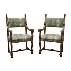  Pair early 20th century oak open armchairs, upholstered back with mask finials and scrolled acanthus leaf uprights, reeded down swept arms with rams head terminals, sprung seat on carved scroll supports joined by stretchers with C scroll feet, W64cm (2)  