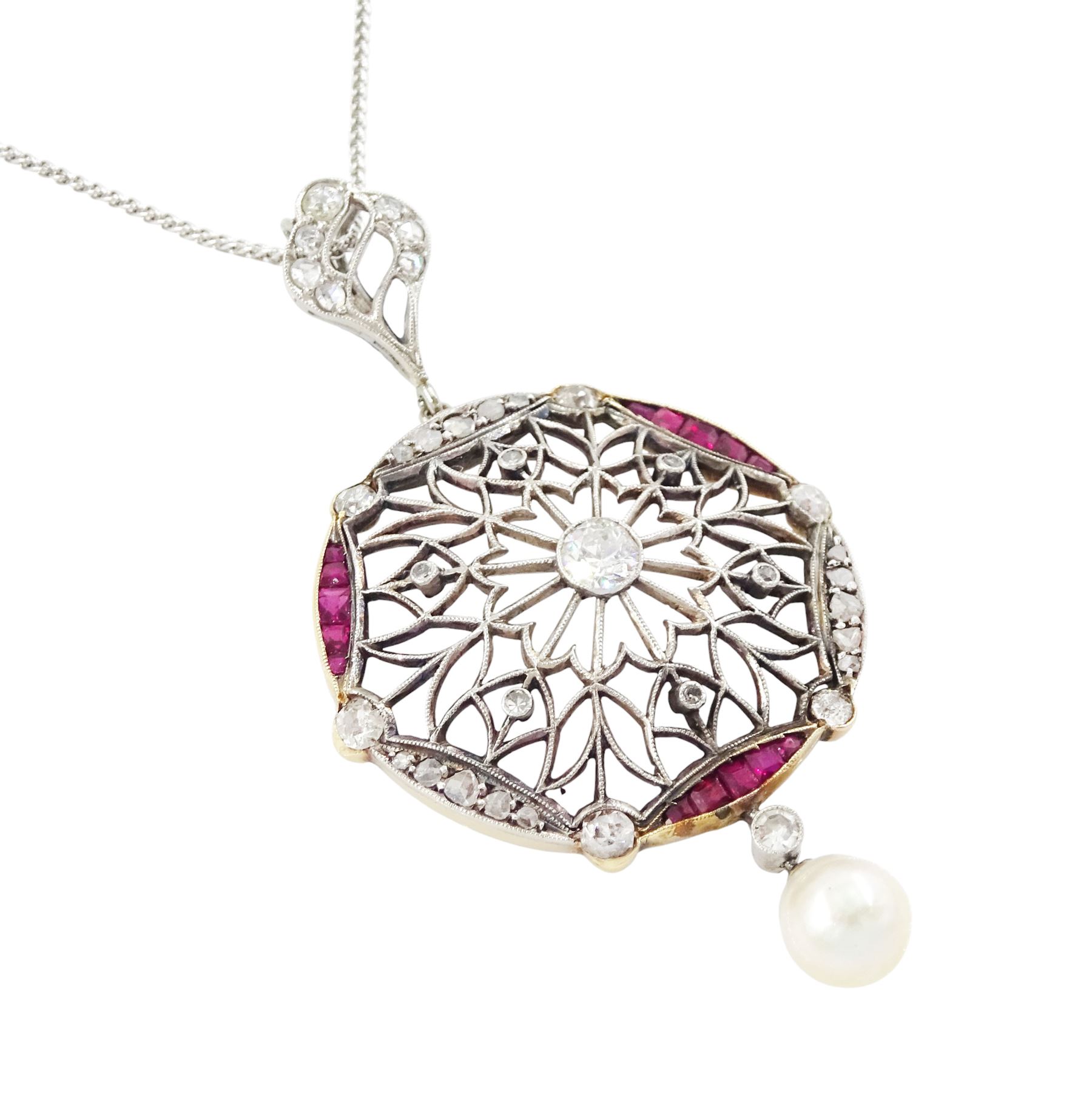 Early 20th century platinum and 18ct yellow gold ruby and diamond circular pendant, single old cut diamond of approx 0.25 carat, within a milgrain pierced fancy foliate surround, set with single cut diamonds, to a navette shaped border set with alternate calibre cut rubies and rose cut diamonds, each spaced by a single old cut diamond, suspending a pearl and diamond drop, on a later 18ct white gold wheat link chain necklace, hallmarked