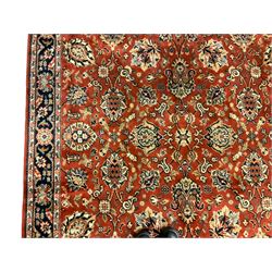 Persian Qual red ground carpet, the field decorated with all-over scrolling palmette decoration and foliate patterns, the guarded border with repeating stylised plant motifs