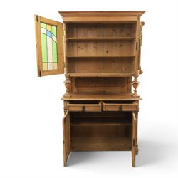 Late 19th century French pine dresser with stained glass upper section, the upper section with projecting cornice with fluted and scrolled details, enclosing a shelved interior, supported on turned front uprights, the lower section with frieze drawers and cupboard doors, raised on bun feet