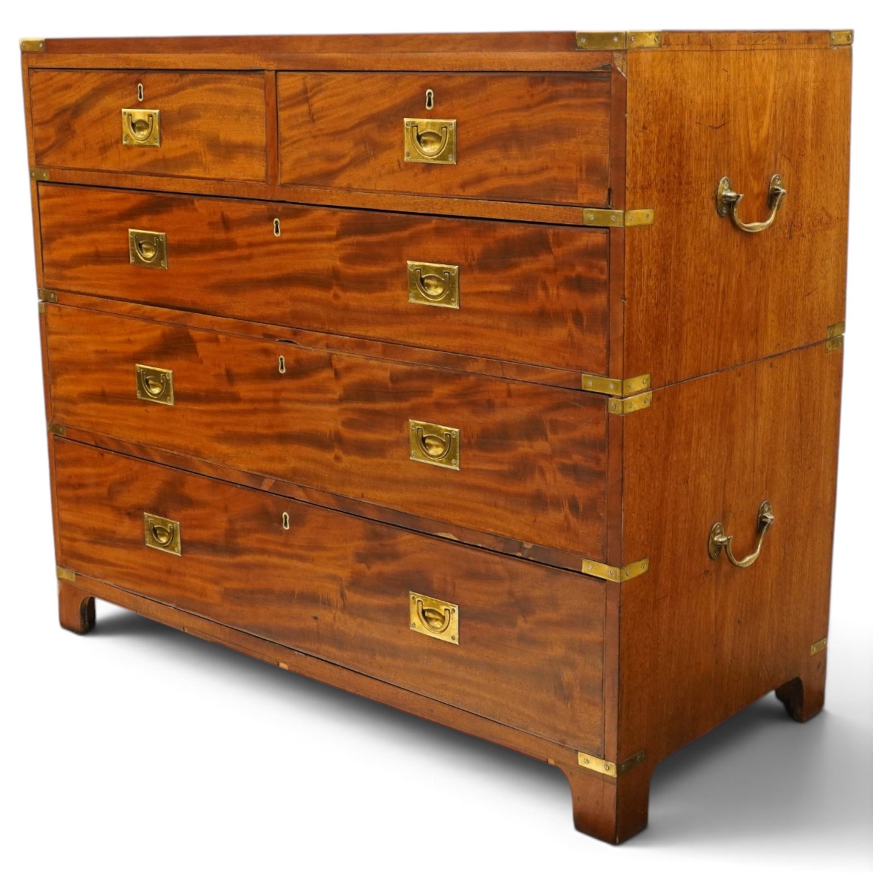 19th century figured mahogany military campaign chest of drawers in two sections, the rectangular top with brass-bound corners over two short and three long graduated drawers, each fitted with recessed brass campaign handles and escutcheons, the carcass with brass strapwork and carrying handles to the sides, raised on short bracket feet