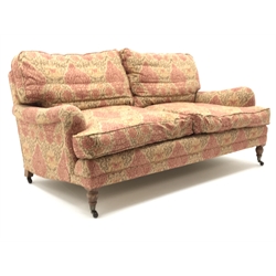  Quality three seat traditional style sofa upholstered in a dark gold and red patterned fabric, turned supports on castors, W180cm  