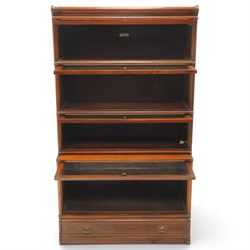 Globe Wernicke - early 20th century mahogany four-tier stacking library bookcase, the shelves fitted with glazed up-and-over doors, fitted with single drawer to the skirted base