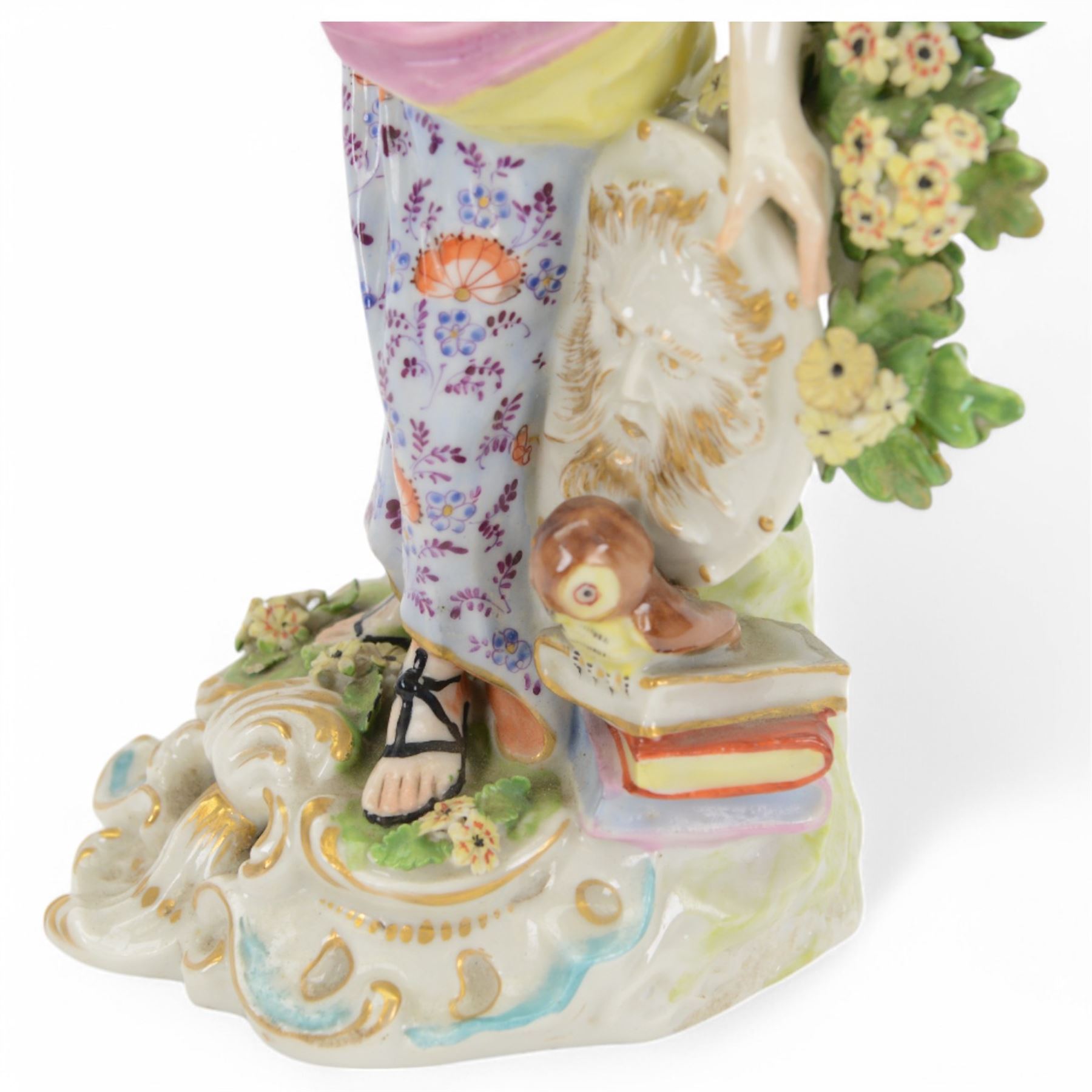 18th century Derby porcelain figure, circa 1775, modelled as Minerva, standing with mask shield, books and owl, against flowering bocage, upon a scroll base encrusted with flowers, H23cm