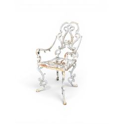 Pair of Victorian cast iron garden chairs, the ornate pierced back of scrolling foliate design, scrolling arm terminals over splayed supports formed of C and S-scrolls, in distressed white painted finish