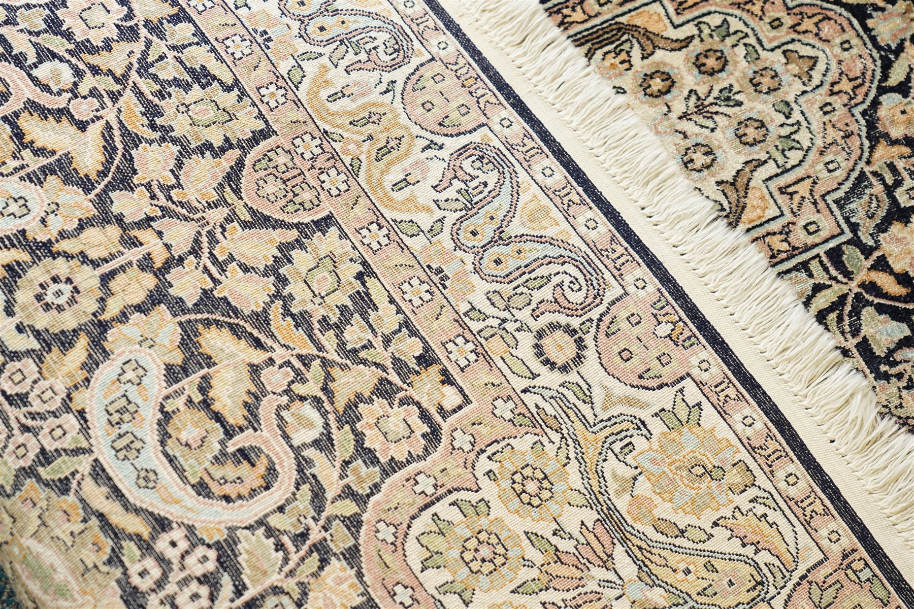 Persian style rug, central medallion with symmetrical floral arabesques, complex and layered borders featuring flowers and scrolling vinework