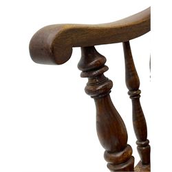 Early 19th century elm farmhouse armchair, the shaped eared cresting rail over tall spindle back, dished seat on turned supports united by H stretchers
