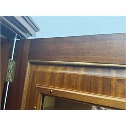 Wylie & Lochhead, Glasgow - early 20th century mahogany and satinwood double wardrobe, projecting cornice over panelled doors, interior fitted with mirrored door, shelves, drawers, hooks and hanging rail, raised on bracket supports with ceramic castors
