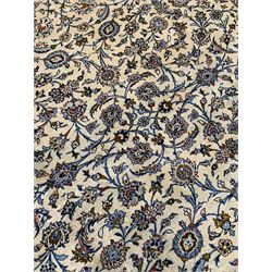 Persian Kashan ivory ground carpet, the field decorated with interlacing leafy branches and stylised plant motifs, repeating border with multiple guards