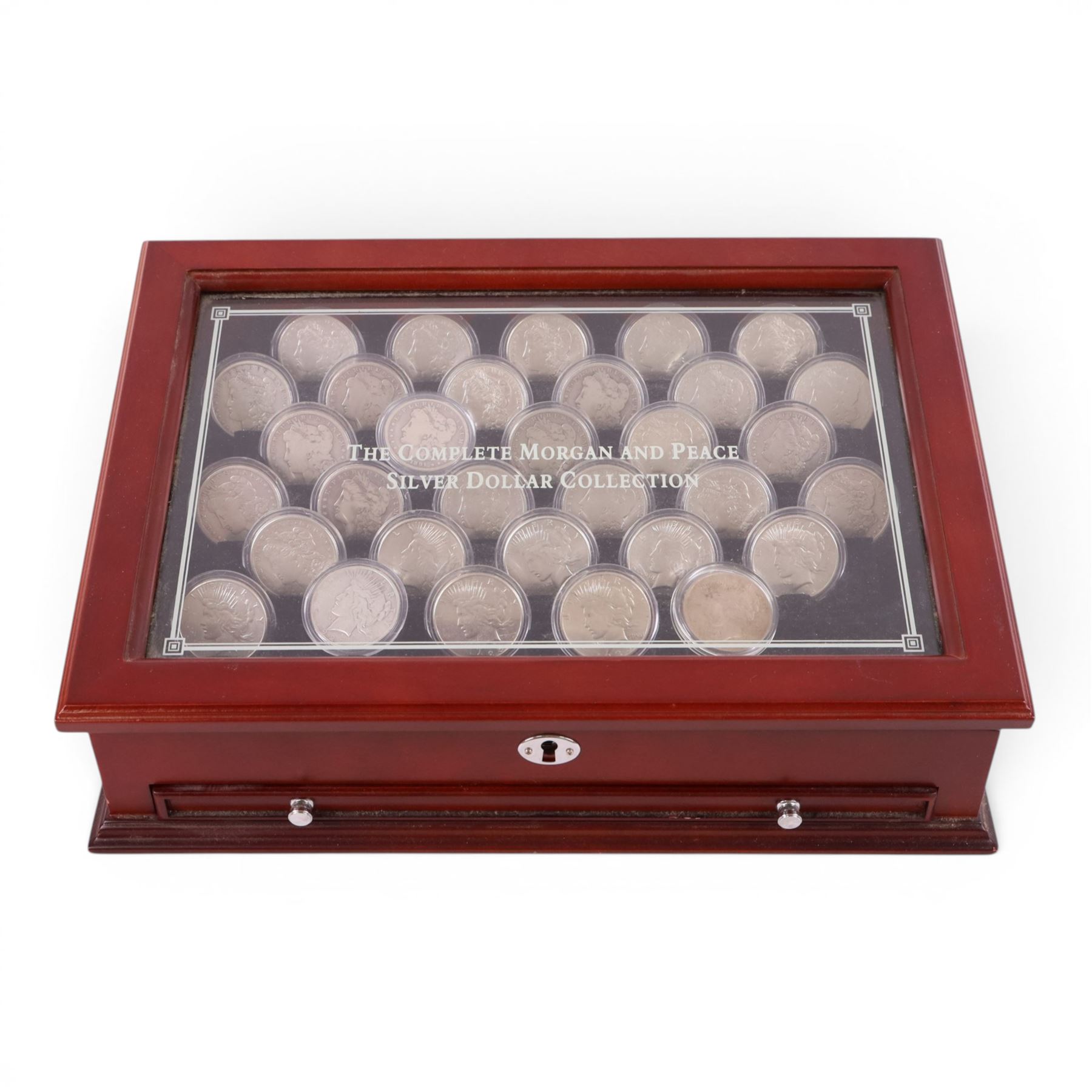 Thirty-two United States of America silver one dollar coins, comprising twenty-three 'Morgan' dollars and nine 'Peace' dollars, presented as 'The Complete Morgan and Peace Silver Dollar Collection', in display case