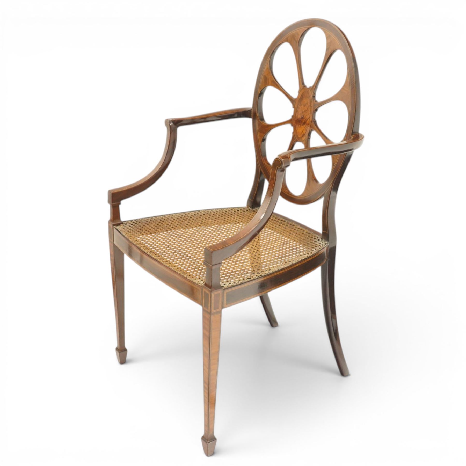 Hampton & Sons (Pall Mall 1830-1957) - Pair of Edwardian inlaid mahogany wheel-back elbow chairs, the pierced oval backs with chequered stringing and cross banding, out-swept arms over canework seats, banded seat rail over square tapering supports with spade feet, stamped to underside
Provenance: Kirkham Hall