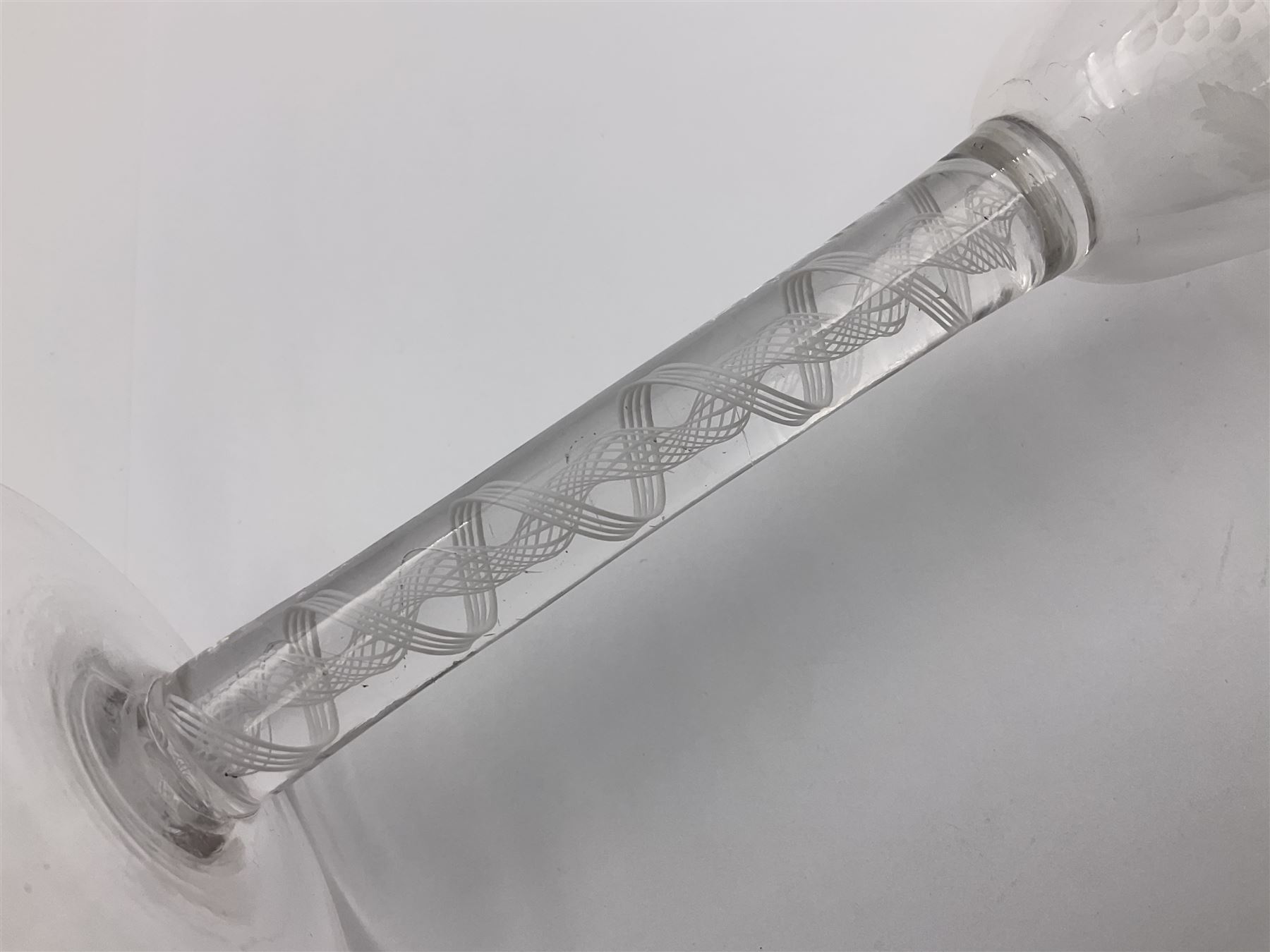 Set of three 18th century style wine glasses, each with funnel bowl etched with fruit vine, upon a double series air twist stem and circular foot, H17cm