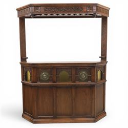 Old Charm - carved oak bar with three bar stools and associated Old Charm drinks cabinet, carved top with channels for glassware beneath, bar surface above glazed panels, shelves for glassware to the back, associated Old Charm drinks cabinet with fall front linenfold carving, above twin doors with shelved interior
