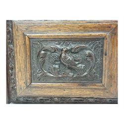 18th century and later carved oak cupboard, enclosed by panelled door carved with central bird motif and scrolled leafage with an outer ebony band, the frieze and uprights carved with repeating lunette and floral designs, flanked by scrolled foliate carved upright brackets