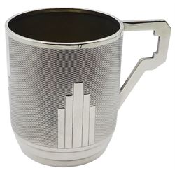 Art Deco silver christening mug, of cylindrical form with engine turned decoration to body and stylised angular handle, upon an inverted stepped foot, hallmarked Sanders & Mackenzie, Birmingham 1931, H7.5cm, approximate weight 3.21 ozt (99.9 grams)