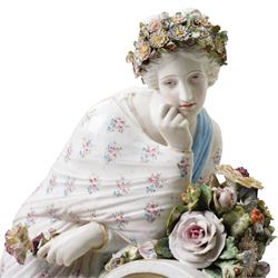 Large19th century  German porcelain mantel clock with white dial and striking movement, the case with a standing figure of Flora resting on a pillar with floral applied decoration, the base painted eith landscape and floral panels on paw feet H77cm W43cm