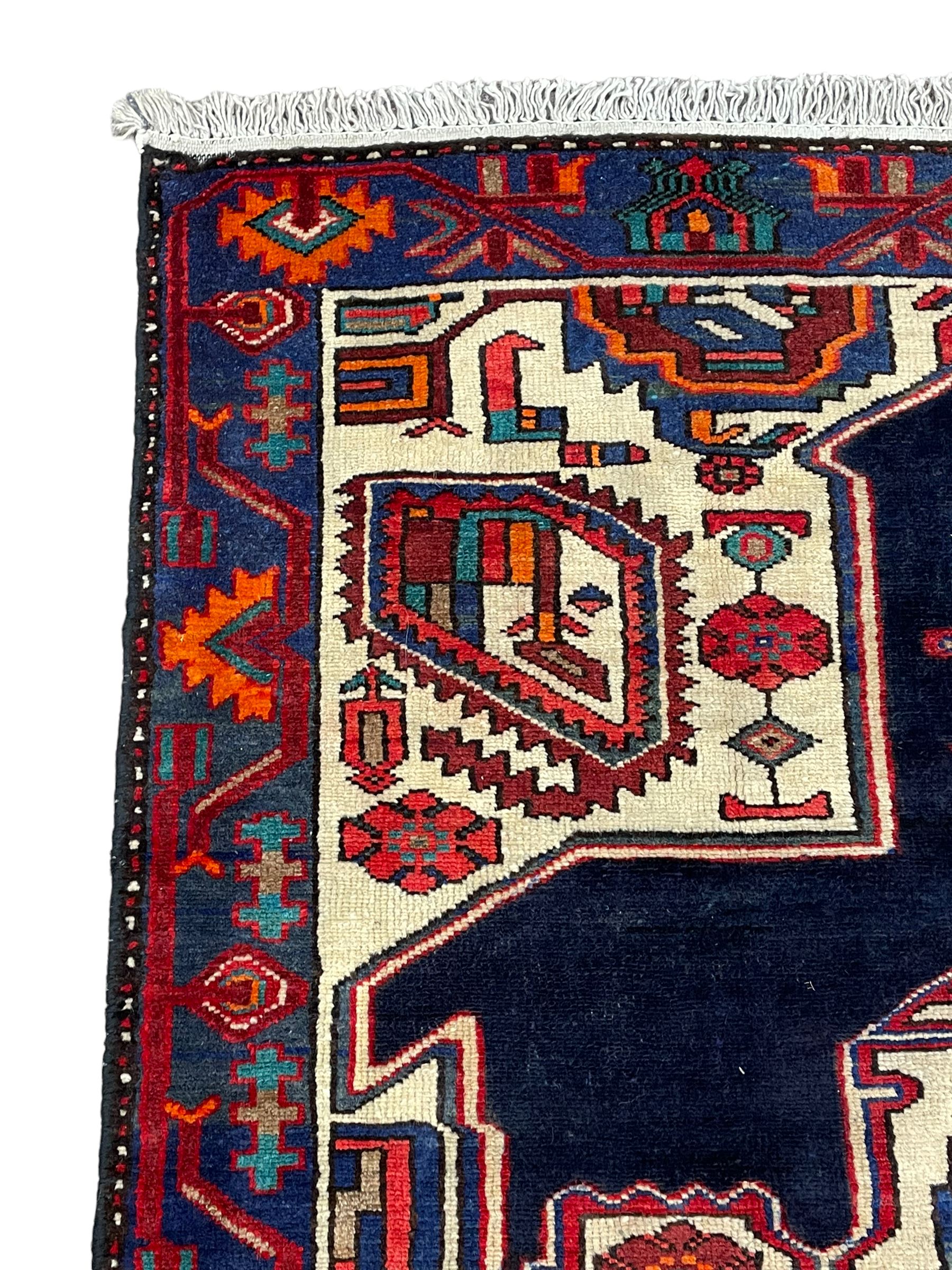 North West Persian Heriz rug, blue and ivory ground, decorated with stylised plant motifs, the border decorated with repeating geometric design 