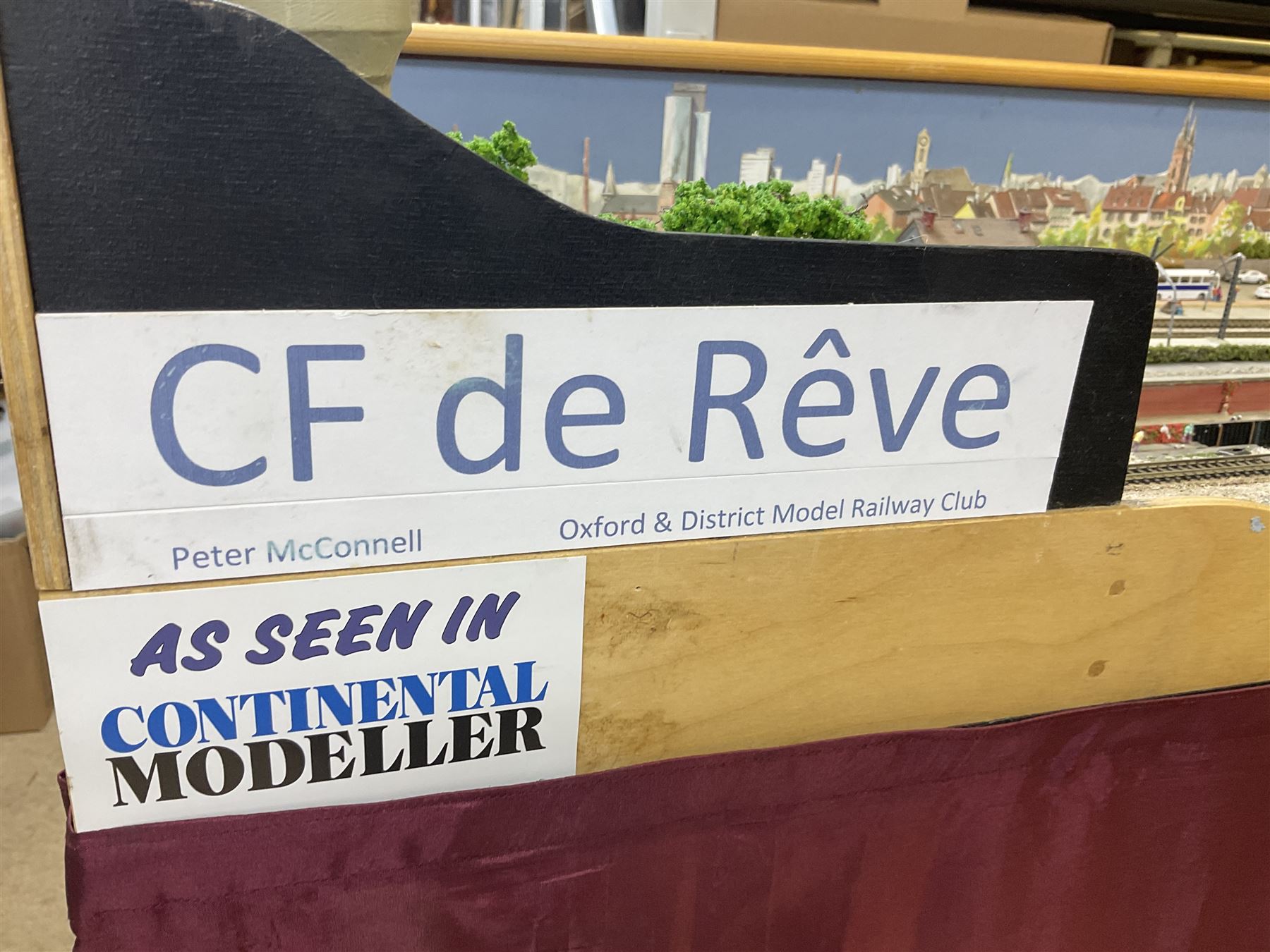 'Z' gauge continental scenic layout with folding legs, various loops of track and sidings with overhead cables, buildings including water tower, tunnels, roads with motor vehicles and figures, trees, haven with boats, backdrop diving wall hiding control units 150 x 50cm