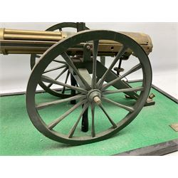 Scratch built brass model of an 1861 Gatling Gun with rotating barrels, hinged cover revealing mechanism, on metal bound wooden spoked wheels and rectangular base L47cm H22cm