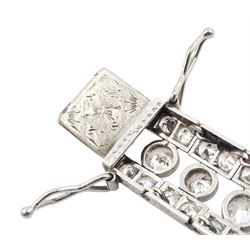 Continental Art Deco platinum old cut diamond openwork bracelet, circa 1920's, twenty-two bezel set graduating diamonds of approx 9.45 carat, the principal diamond approx 0.90, with a row milgrain set diamonds either side, the clasp set with a single diamond, the bracelet sides and clasp with engraved foliate decoration, total diamond weight approx 20.60 carat