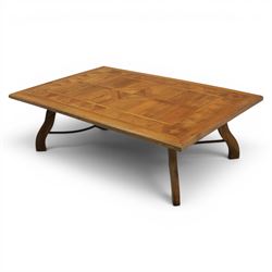 20th century Spanish design oak coffee table, rectangular parquetry top with geometric star and triangular inlaid decoration, moulded edge, on shaped trestle end supports united by black painted wrought iron scroll stretchers