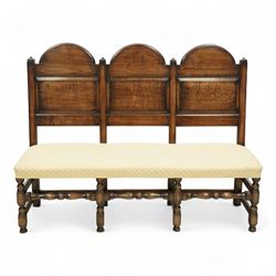 Bylaw of Ross On Wye - 17th-century design oak three-seat hall bench, triple arched panelled back, padded seat upholstered in a yellow herringbone ground fabric with star motif, raised on turned baluster legs united and turned front stretcher