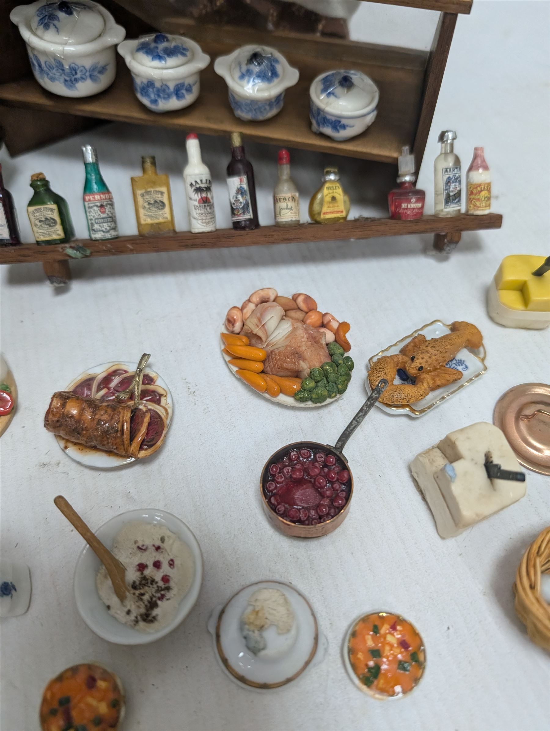 Victorian and later style dolls house kitchen furniture, including countertop, dresser displaying copper pots and blue and white ceramics, baking table, oven, three figures and a collection of food and baking accessories