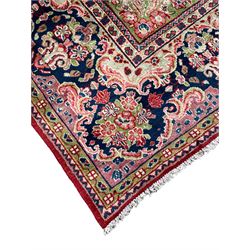 Persian Mahal crimson ground carpet, the plain field with floral spandrels and a foliate bordered central medallion, the indigo guarded border with repeating plant motifs and scrolling