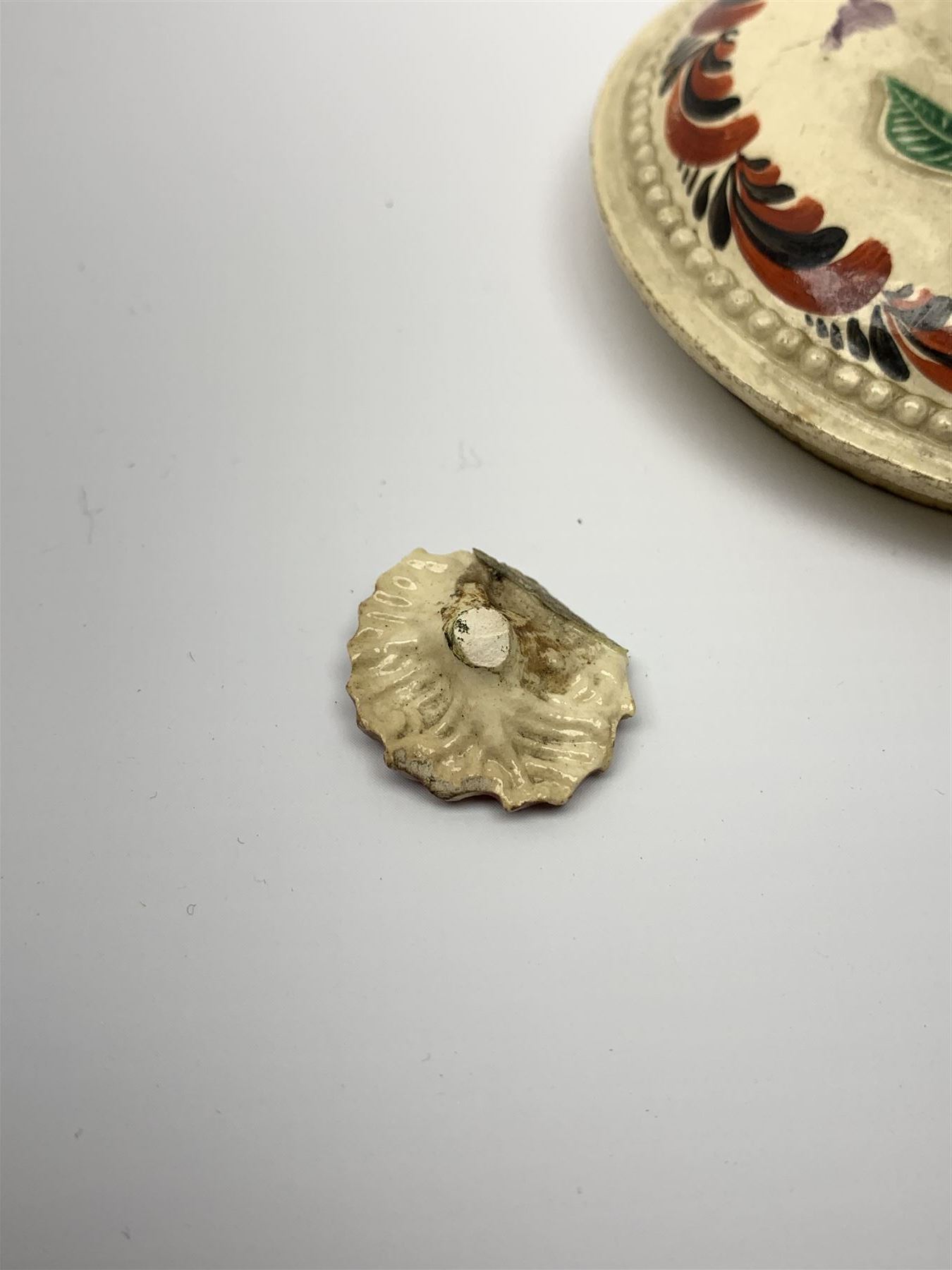 18th century creamware teapot, probably Leeds, with reeded entwined handle and floral finial to the cover, the body with hand painted polychrome decoration of figure to one side, and floral spray to the other, collectors paper label beneath inscribed Leeds Pottery, H11.5cm