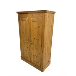Solid pine double wardrobe enclosed by two panelled doors