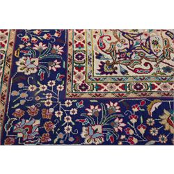 North West Persian Tabriz hand-knotted carpet, madder red field with a central cusped medallion issuing radiating pendants and an all-over design of scrolling arabesques, palmettes and flowering vinery enclosed by conforming spandrels, indigo main border of meandering floral vines and stylized palmettes, flanked by narrow guard stripes, cotton fringe ends 